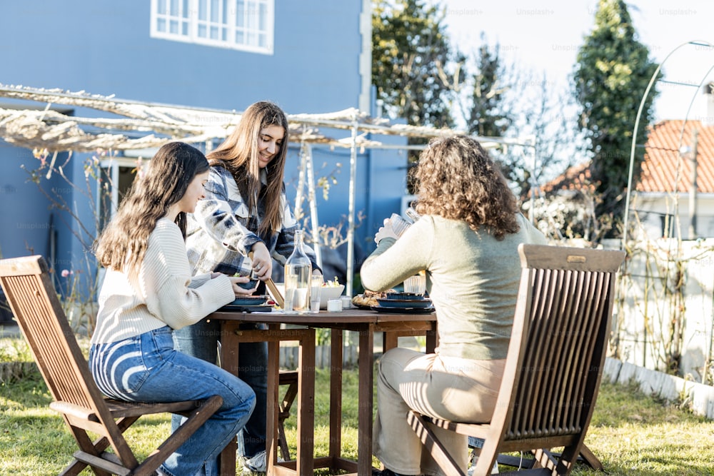 um grupo de mulheres sentadas em uma mesa do lado de fora