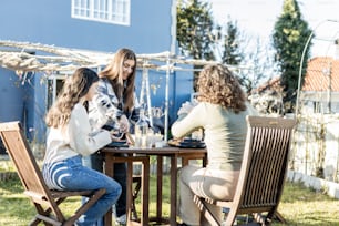 a group of women sitting at a table outside