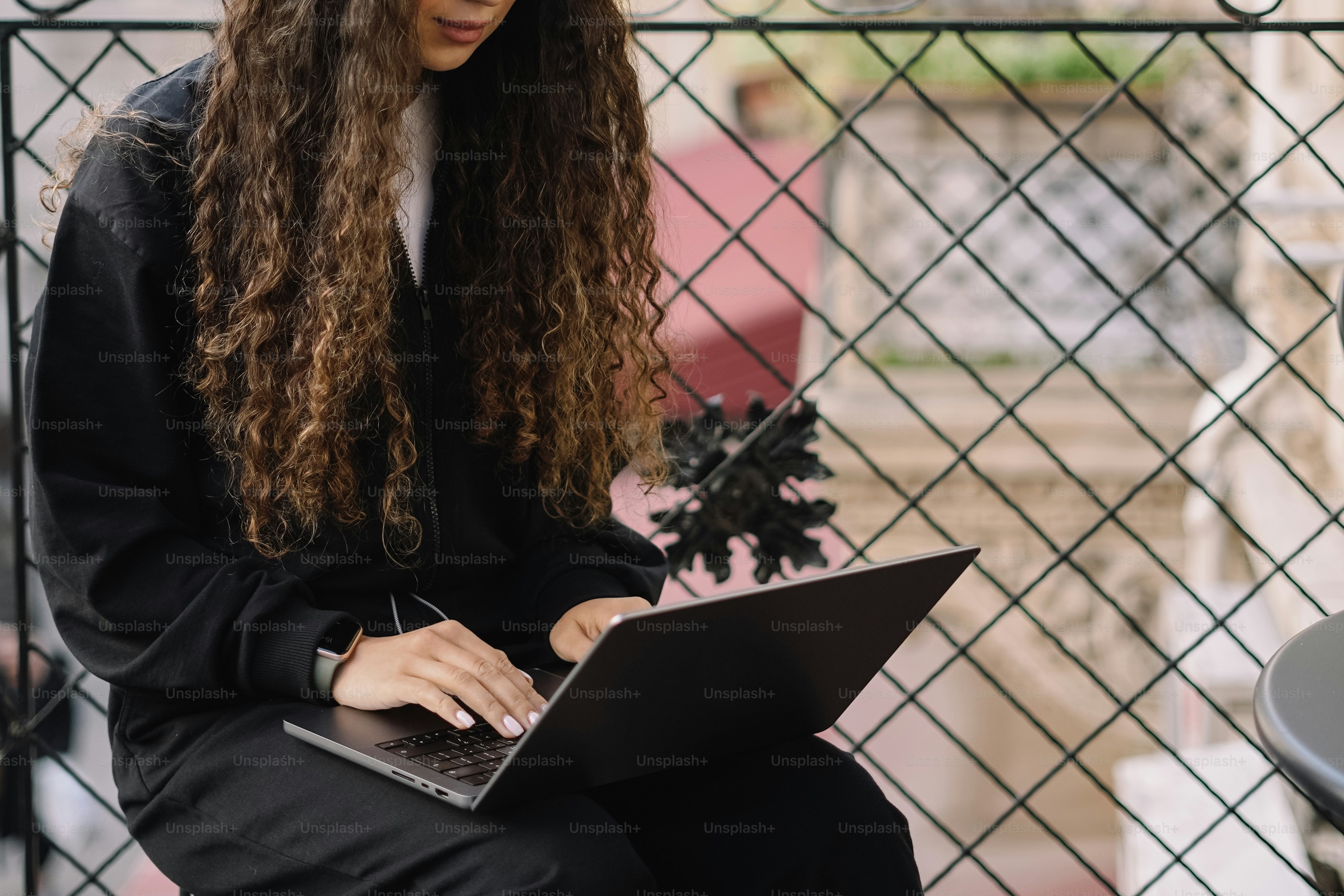 a woman sitting on a bench using a laptop computer