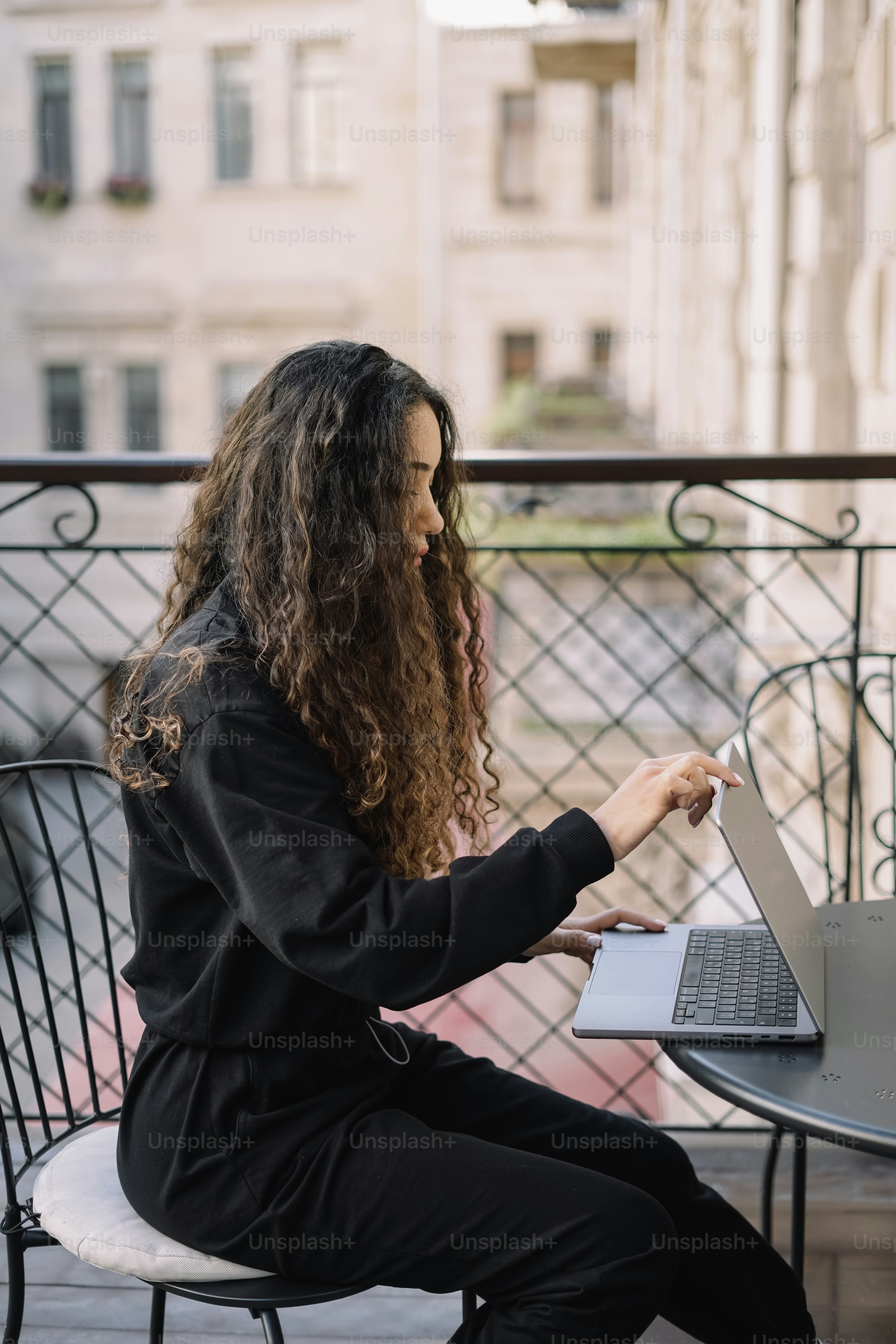 ノートパソコンを使ってテーブルに座る女性
