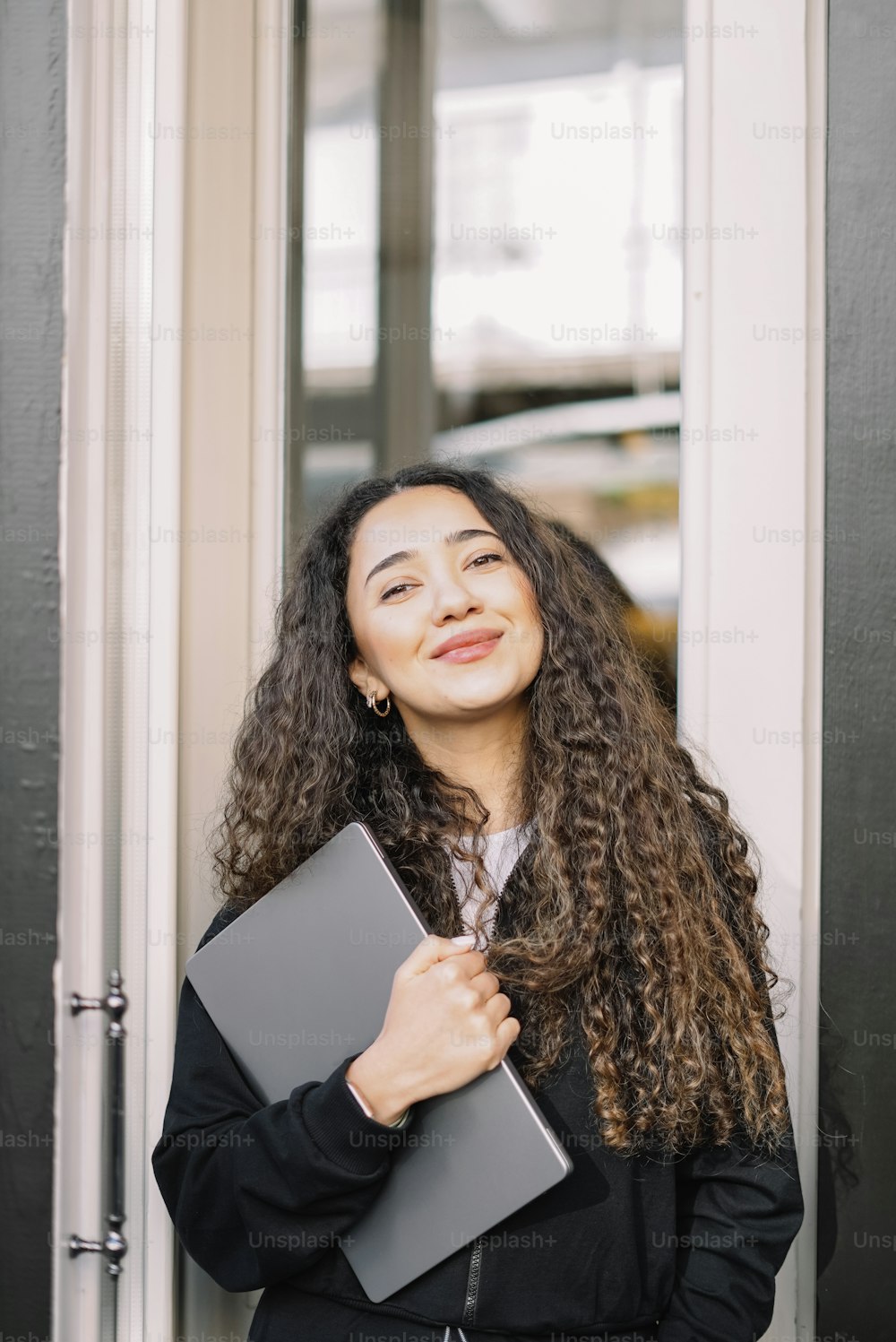 a woman with curly hair holding a folder