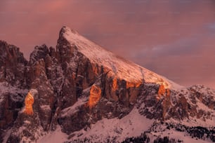 a mountain covered in snow under a cloudy sky