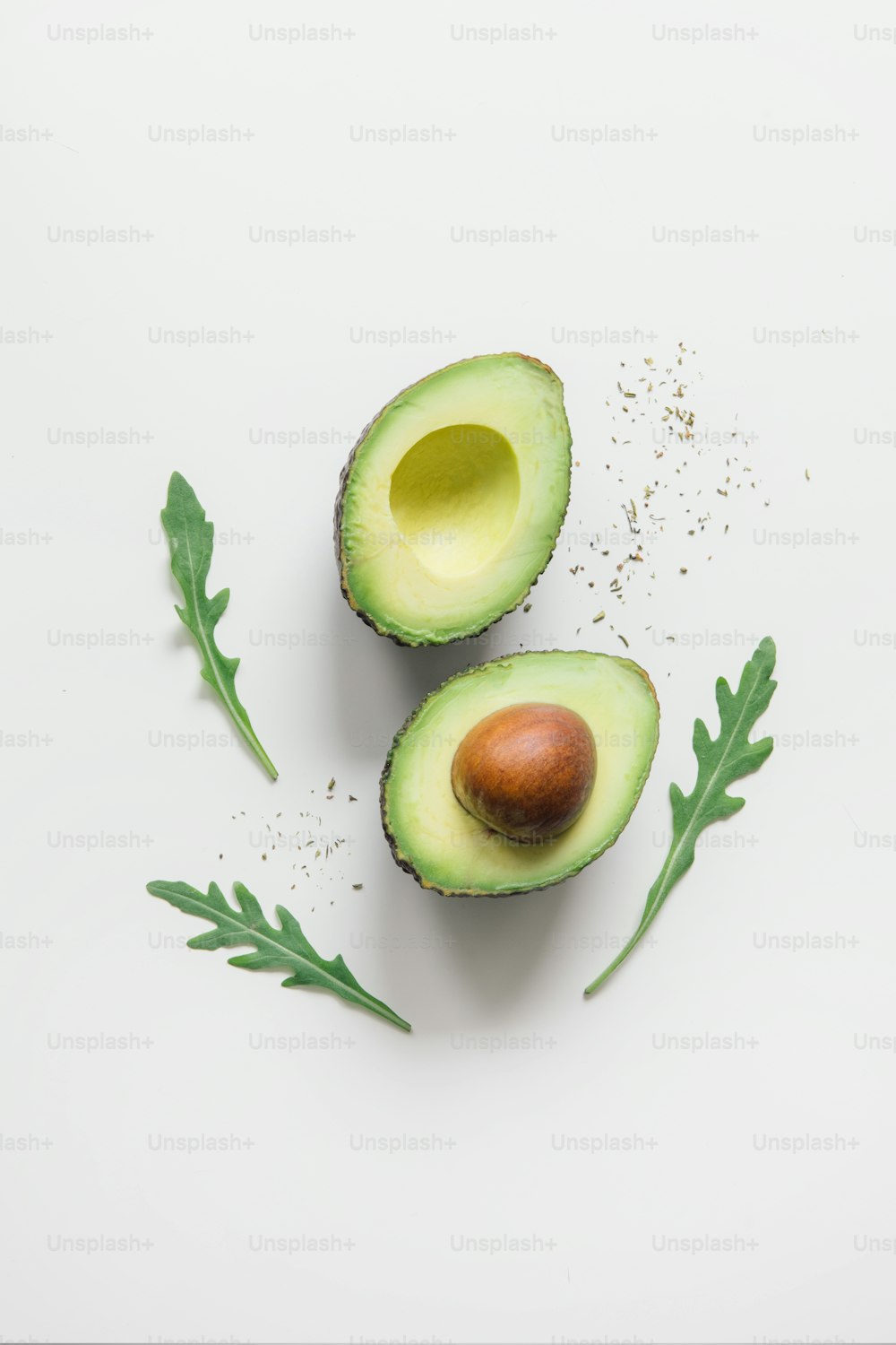 an avocado cut in half on a white surface