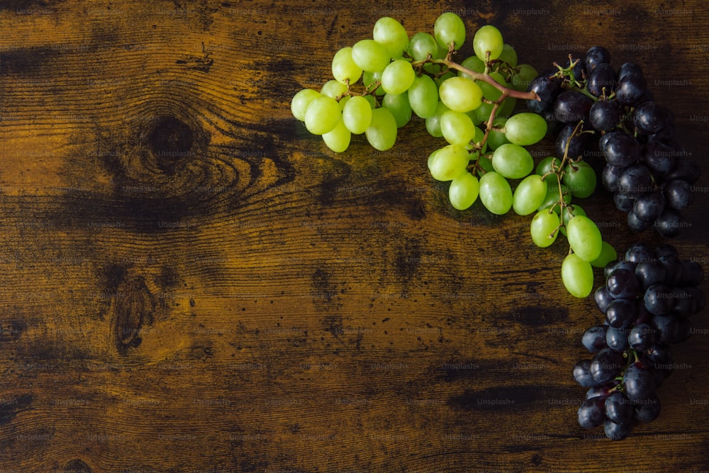 a bunch of grapes sitting on top of a wooden table