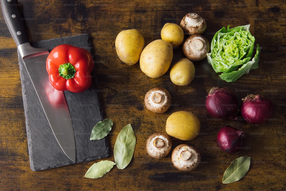 uma tábua de corte com legumes e uma faca sobre ela
