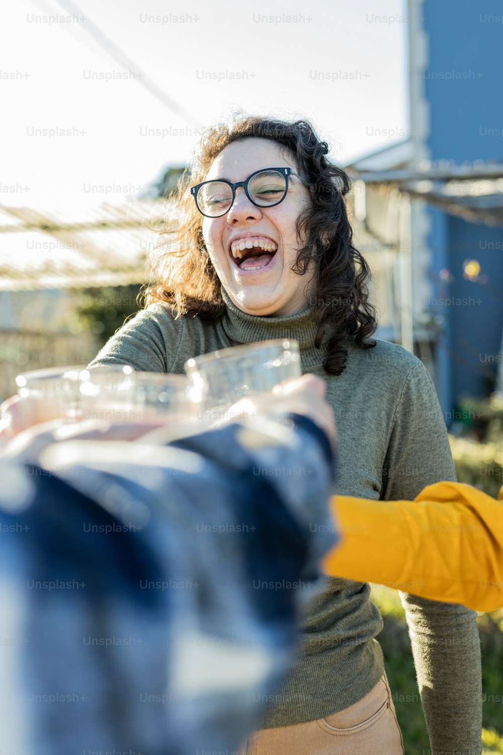 Una mujer riendo mientras sostiene un recipiente de plástico