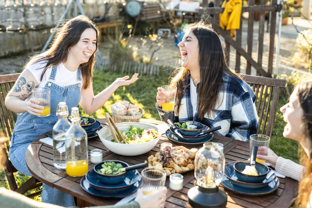 テーブルの周りに座って食べ物を食べる女性のグループ