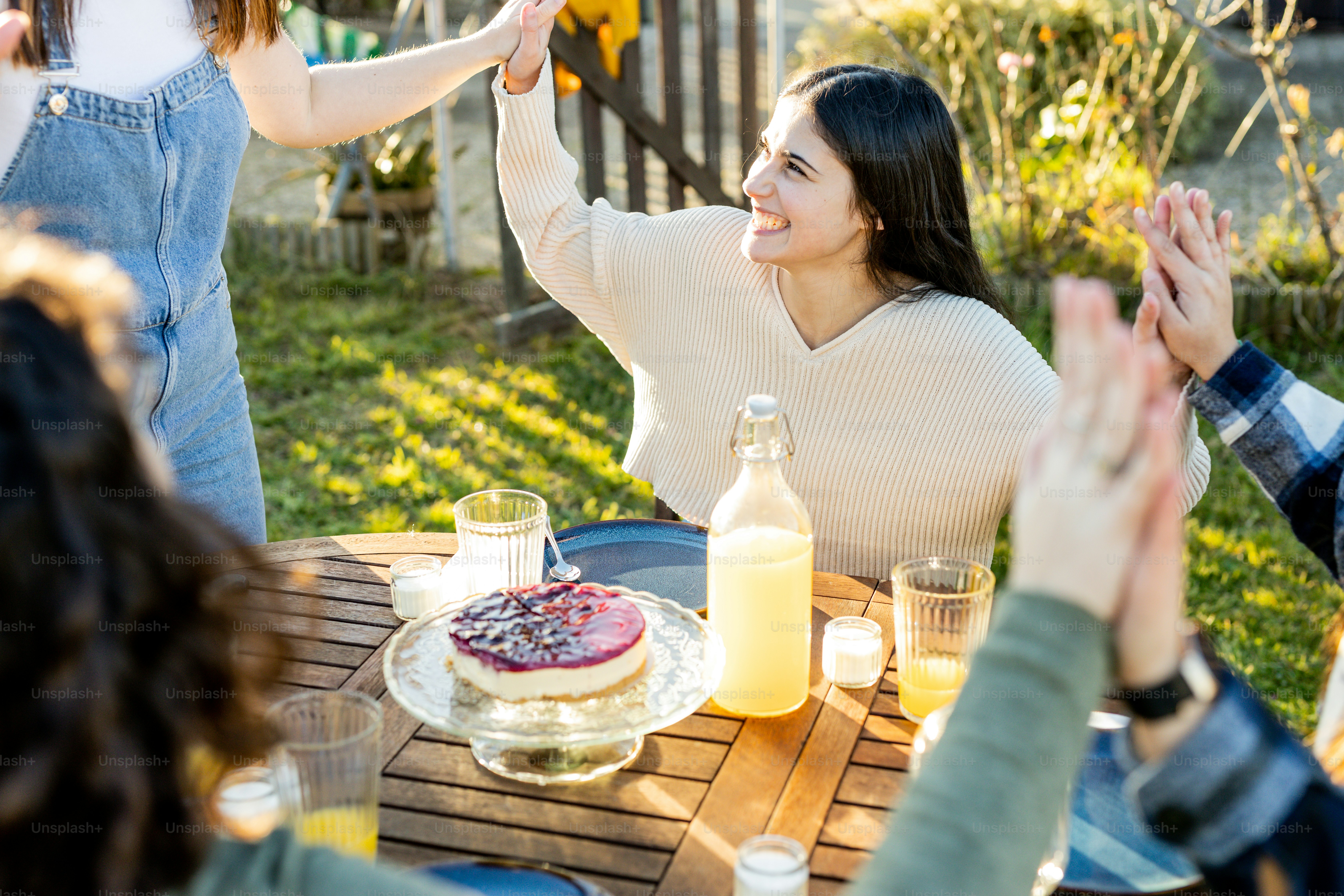 Un groupe de personnes assises autour d’une table avec un gâteau photo ...