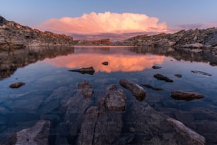 Un lago rodeado de rocas bajo un cielo nublado
