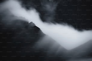 Una foto in bianco e nero di montagne e nuvole