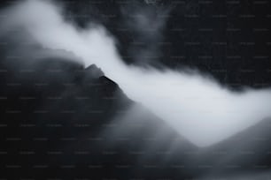 a black and white photo of mountains and clouds