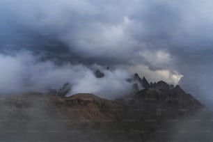 Un grupo de montañas cubiertas de nubes en un día nublado