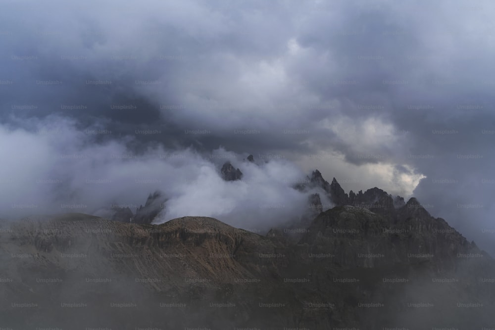 a group of mountains covered in clouds on a cloudy day