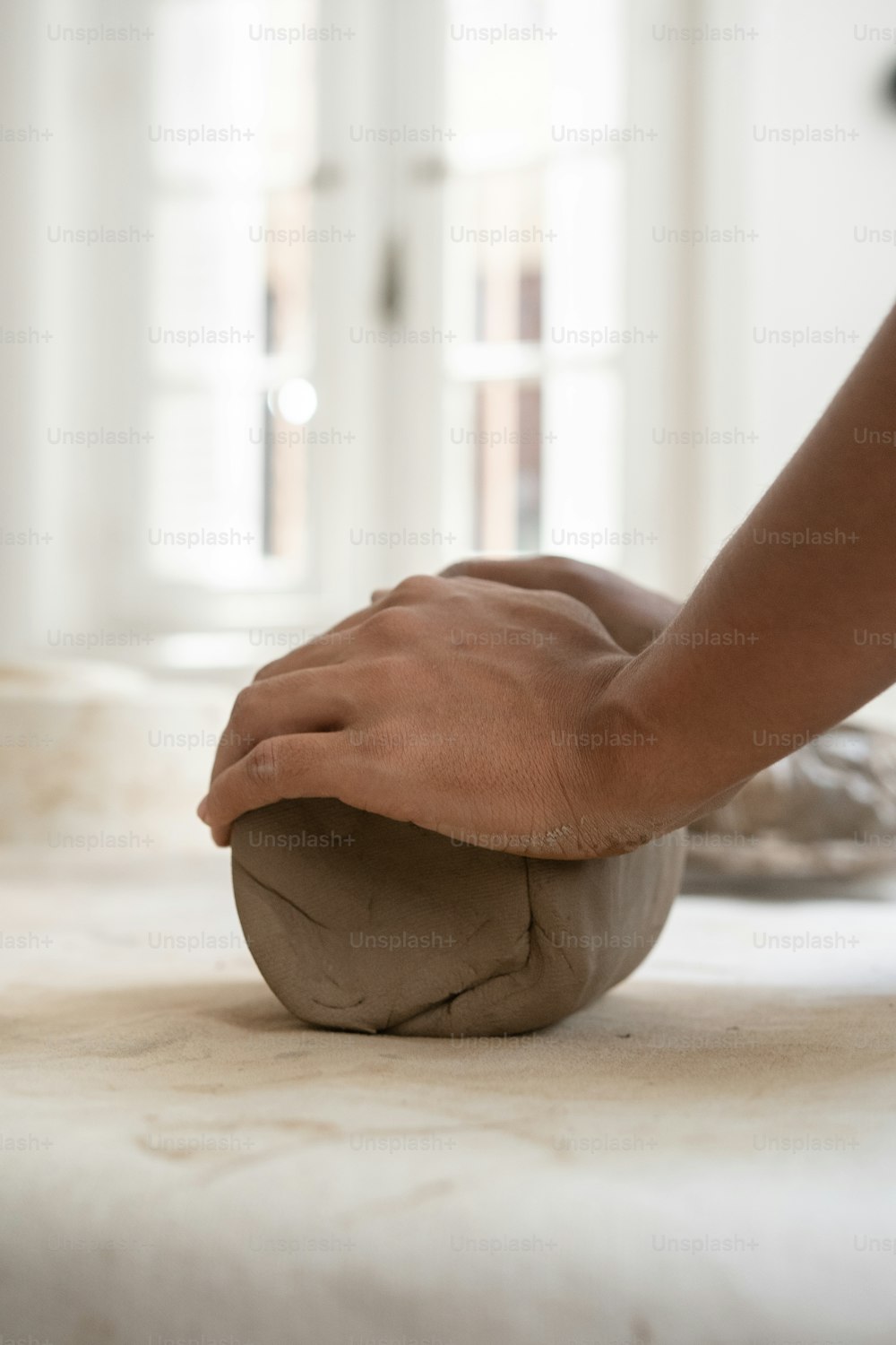 a person is kneading a ball of dough on a table