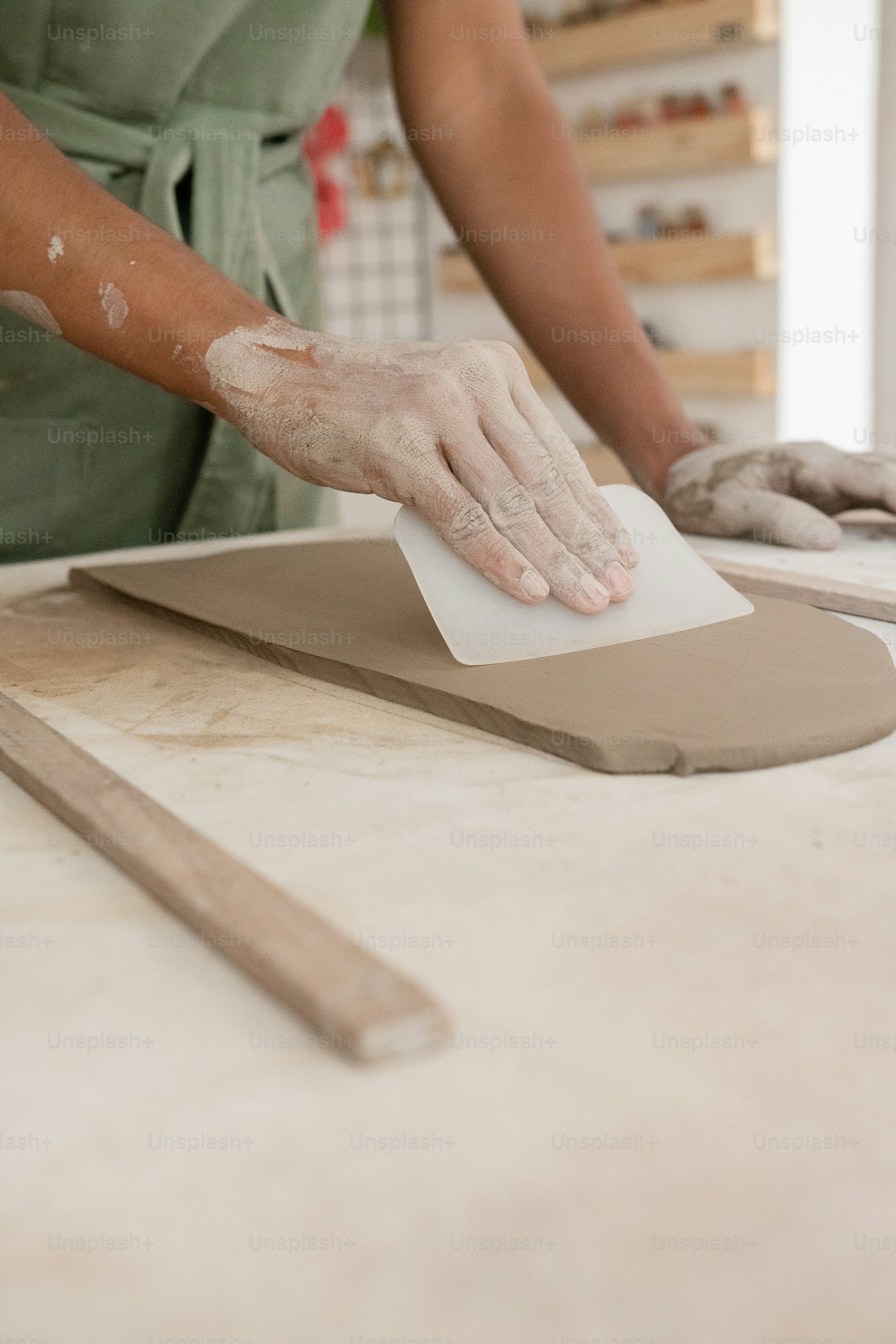 uma pessoa em um avental verde está trabalhando em uma mesa