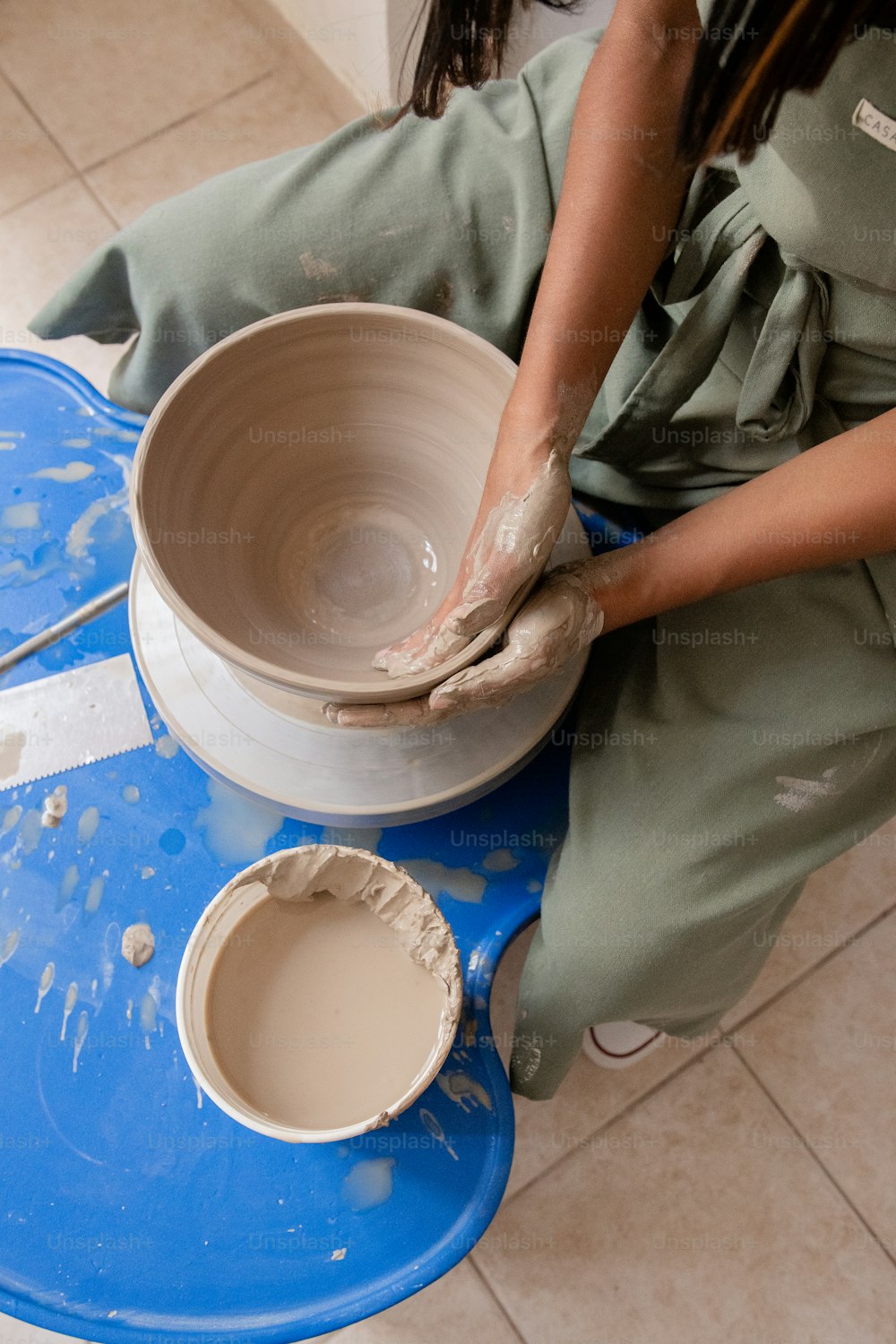 한 여자가 진흙으로 그릇을 만들고 있다