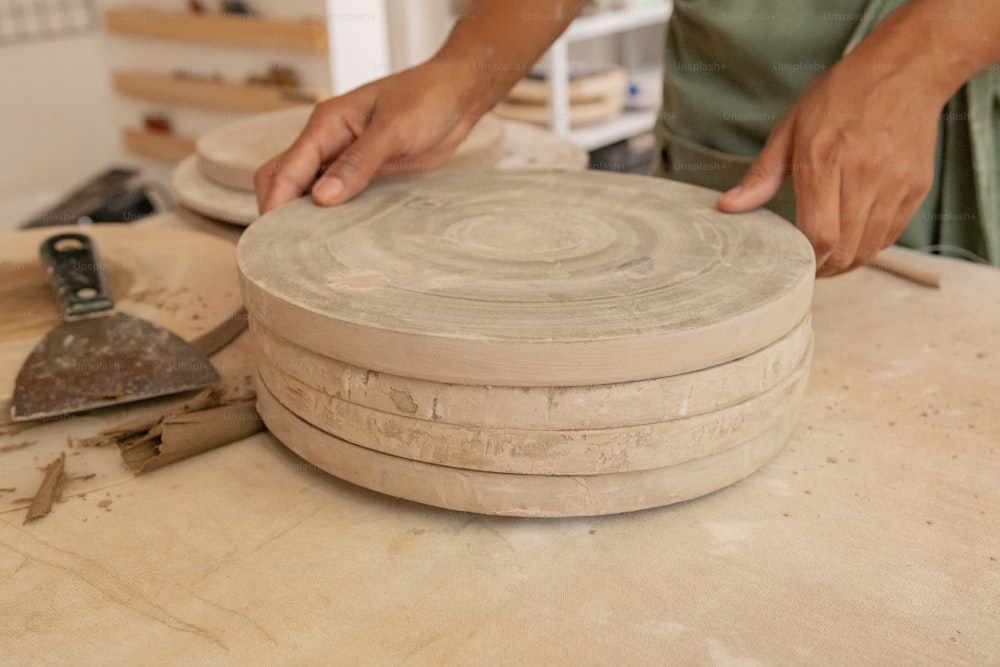 eine Person, die an einem Stück Keramik arbeitet
