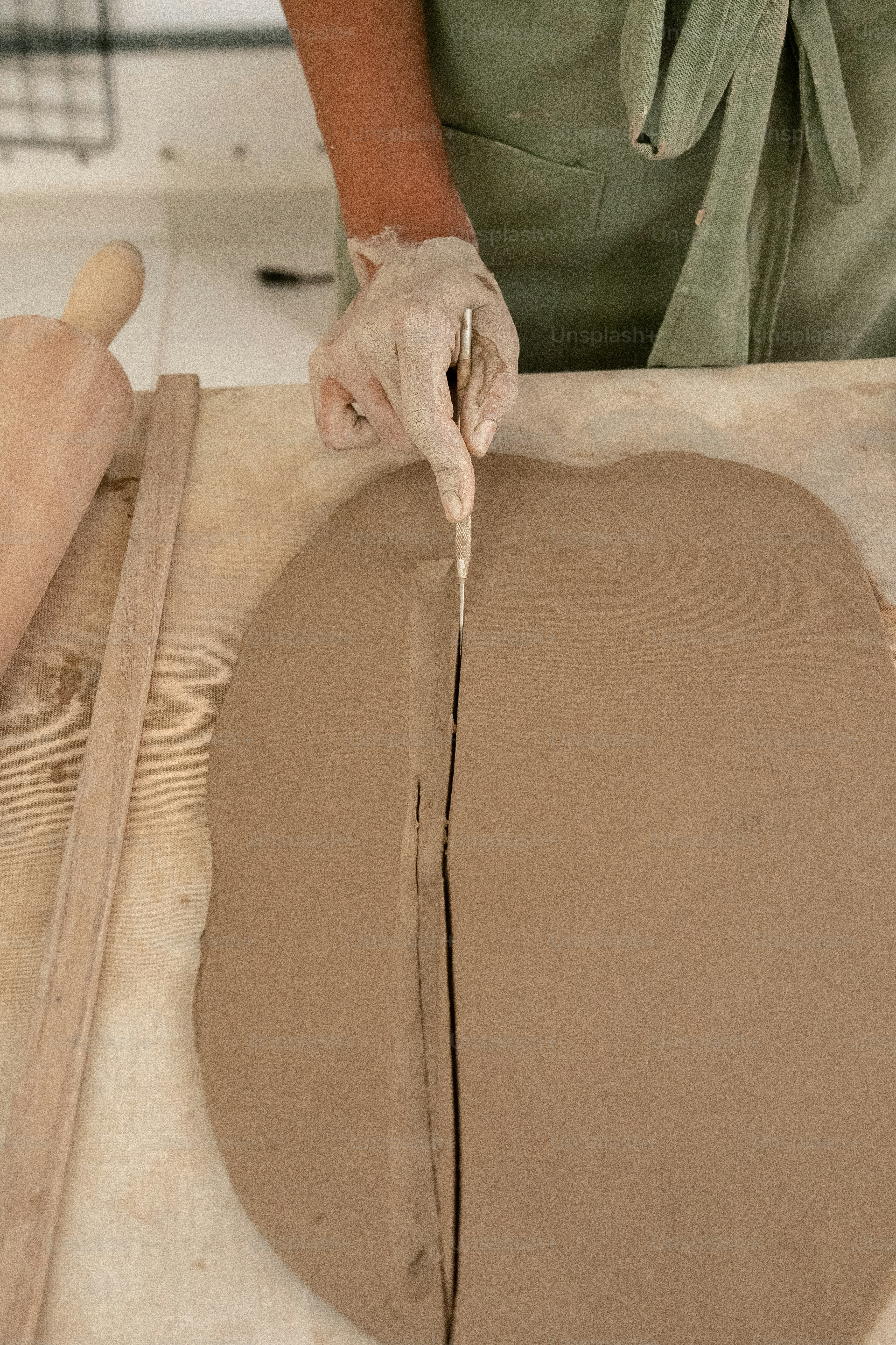 Una persona con una camisa verde está haciendo una masa