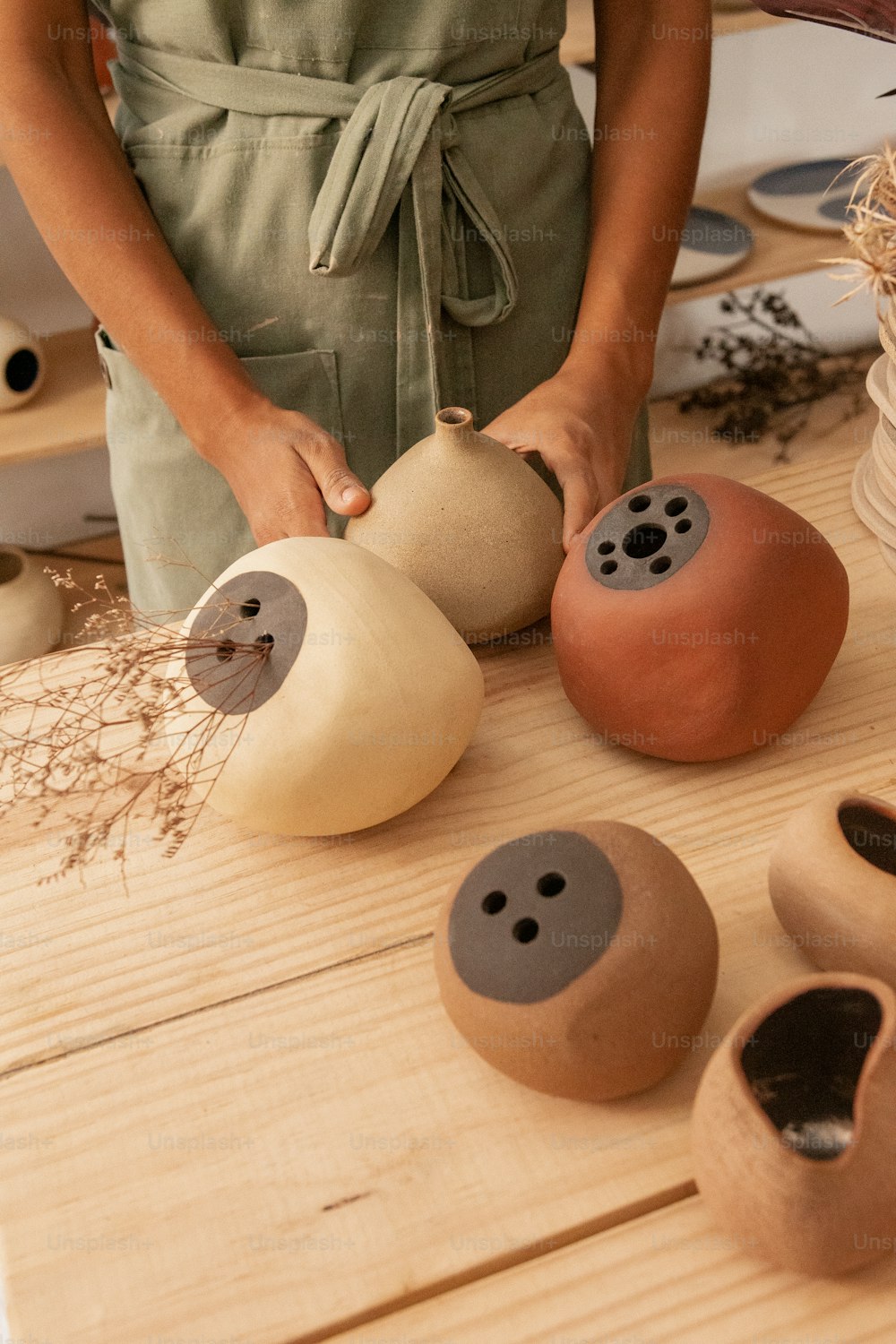 une personne debout devant une poterie
