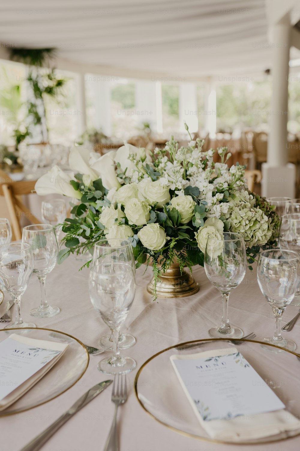 Une table est dressée avec des verres à vin et des fleurs