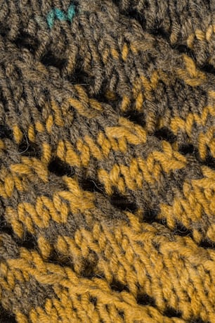 a close up of a crochet blanket with a green button