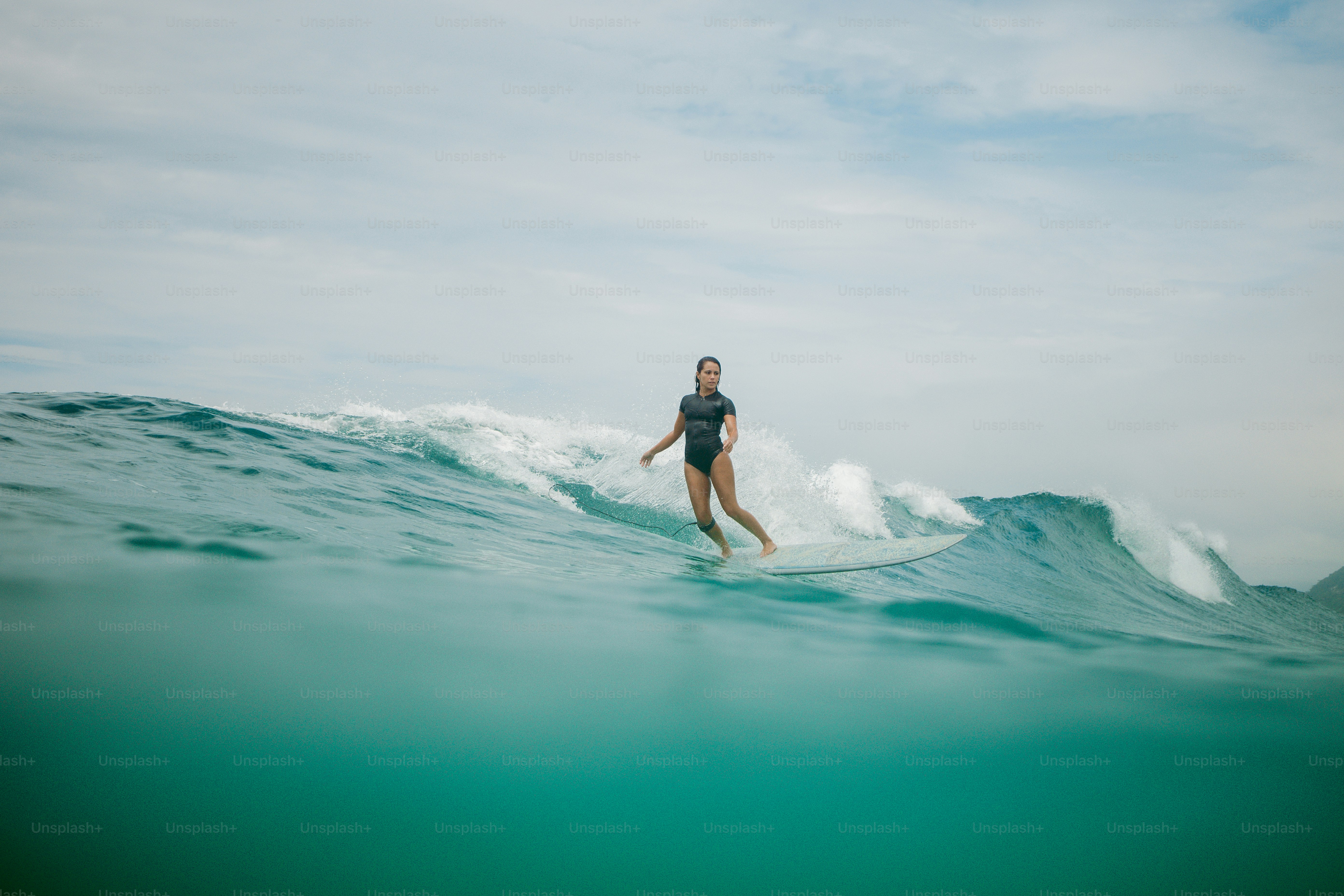 a woman riding a wave on top of a surfboard