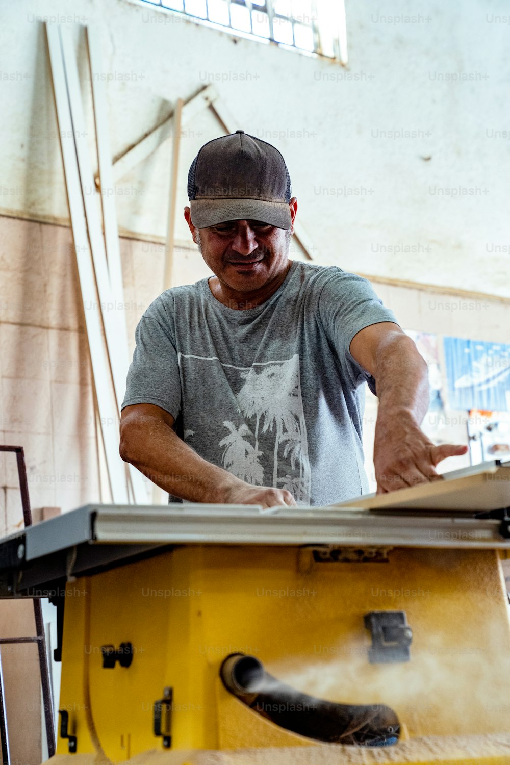Un hombre cortando un trozo de madera con una sierra