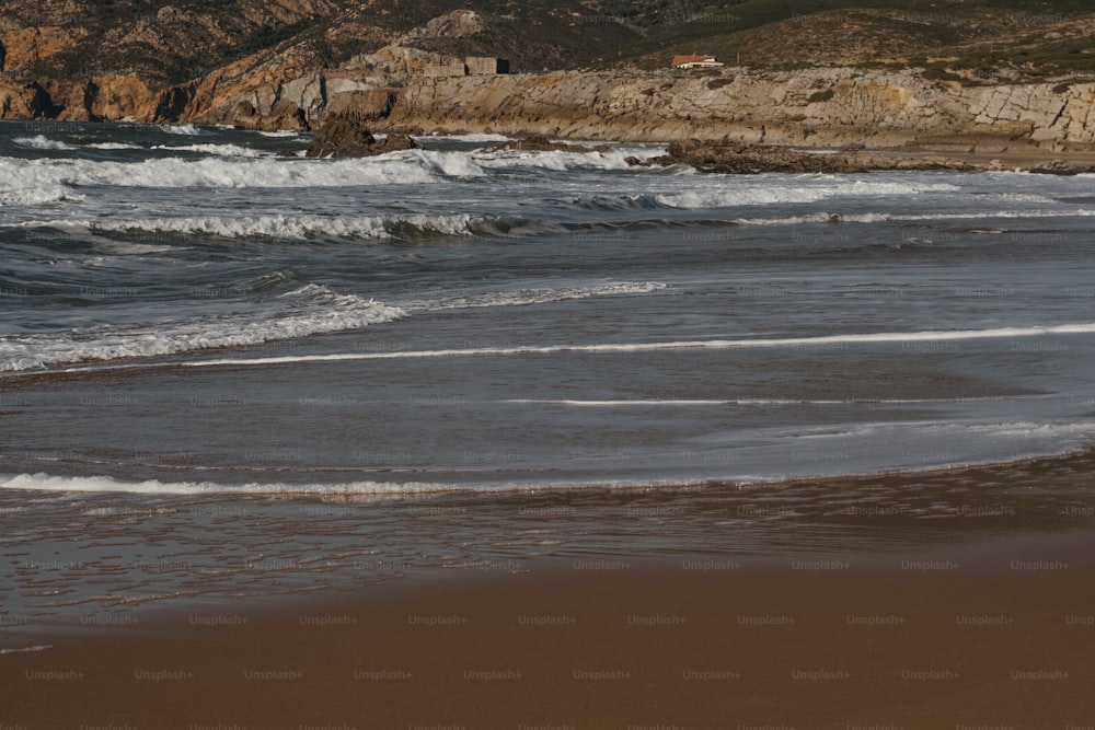 Eine Person, die mit einem Surfbrett am Strand spazieren geht