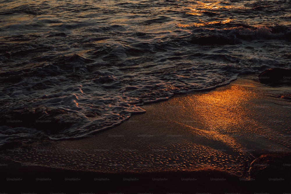 El sol se está poniendo sobre el agua en la playa