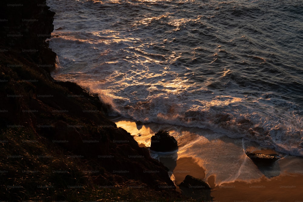 a body of water sitting next to a rocky cliff