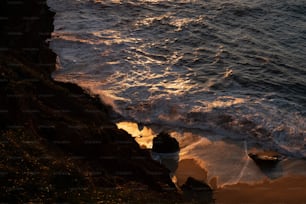 a body of water sitting next to a rocky cliff