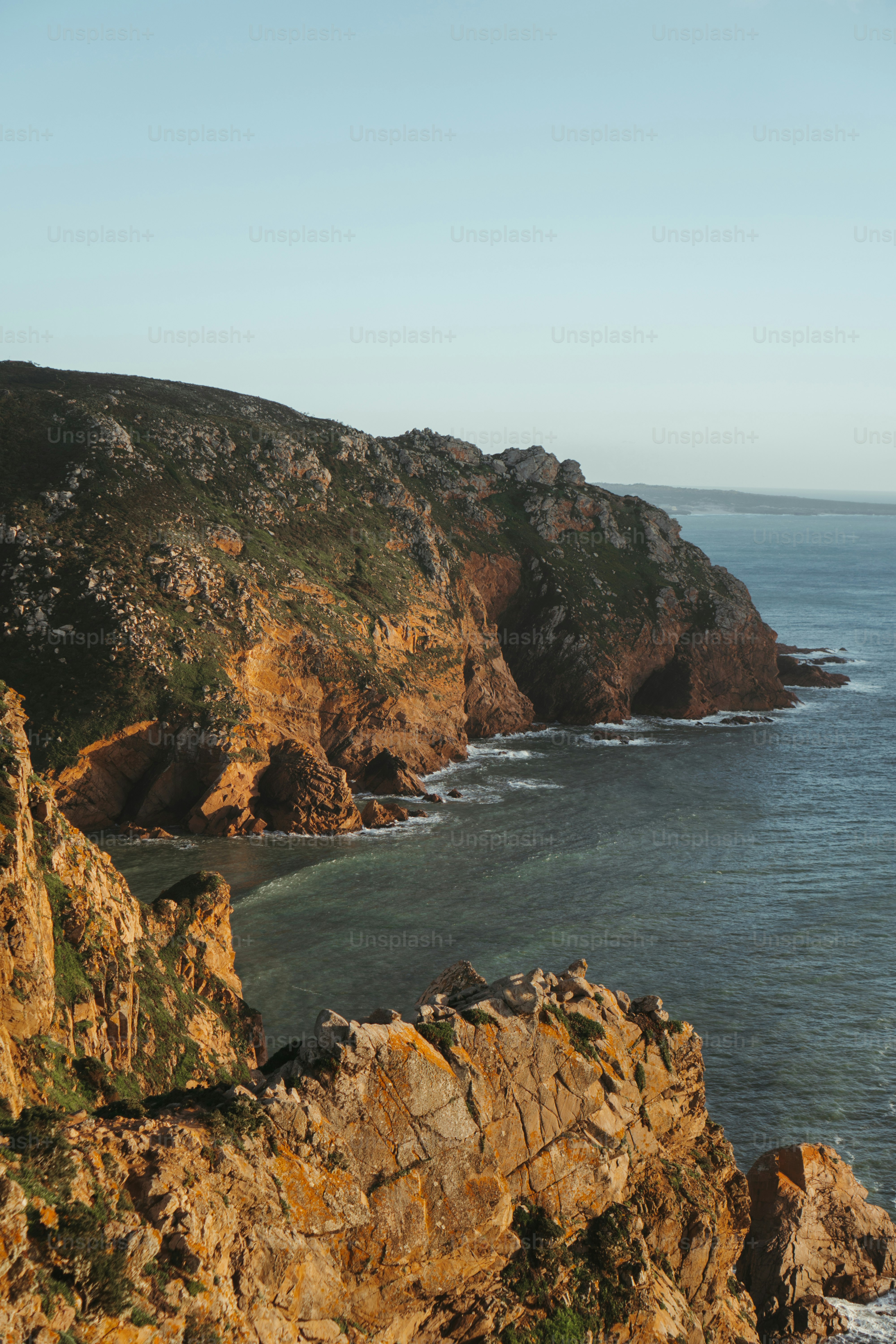a large body of water sitting next to a rocky shore