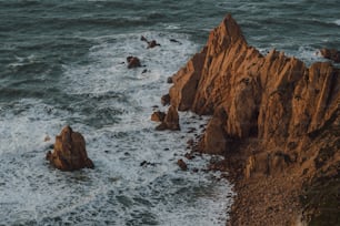 Un grupo de rocas sentadas en la cima de una playa rocosa