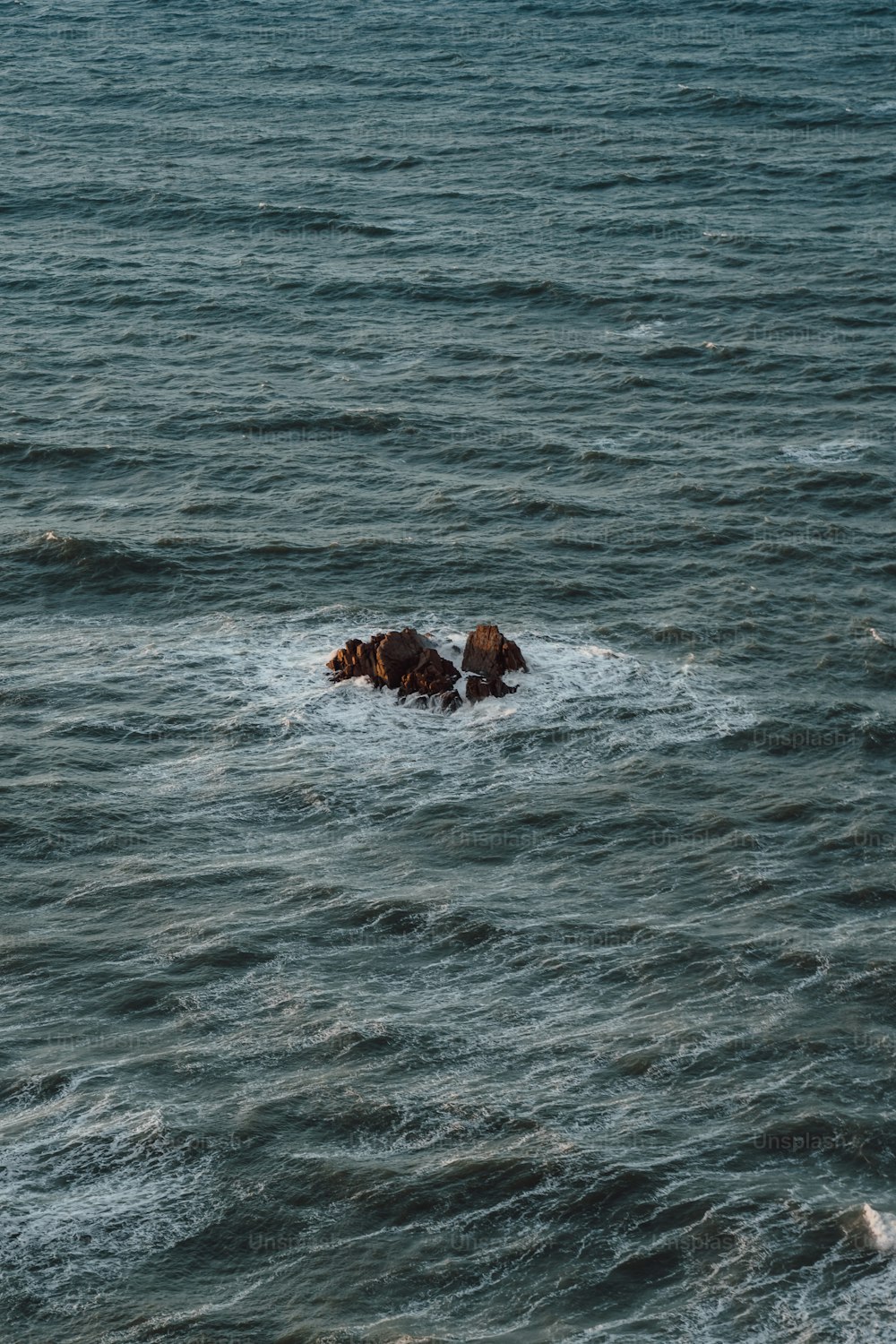 a couple of rocks in the middle of a body of water