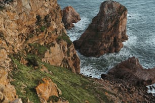 a couple of large rocks sitting on top of a lush green hillside