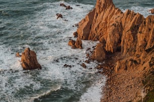 une vue aérienne de l’océan avec des rochers au premier plan