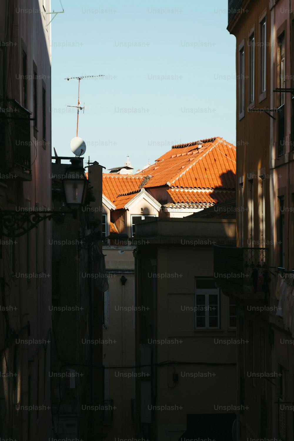 a view of a rooftop from a narrow alley way