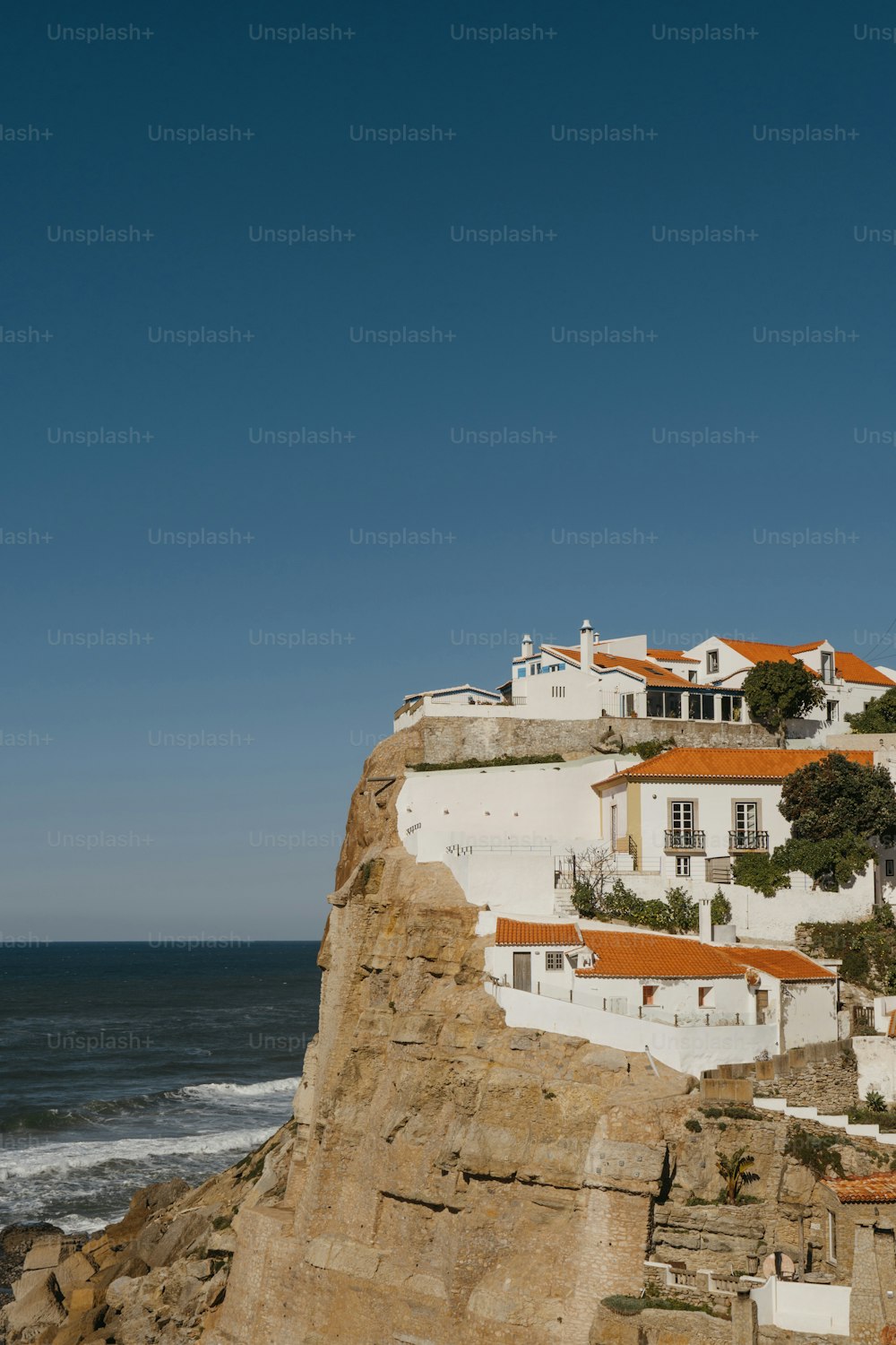 a white house on a cliff overlooking the ocean