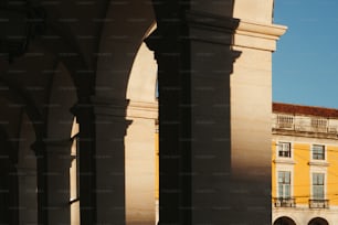 Un edificio con arcos y una torre del reloj al fondo