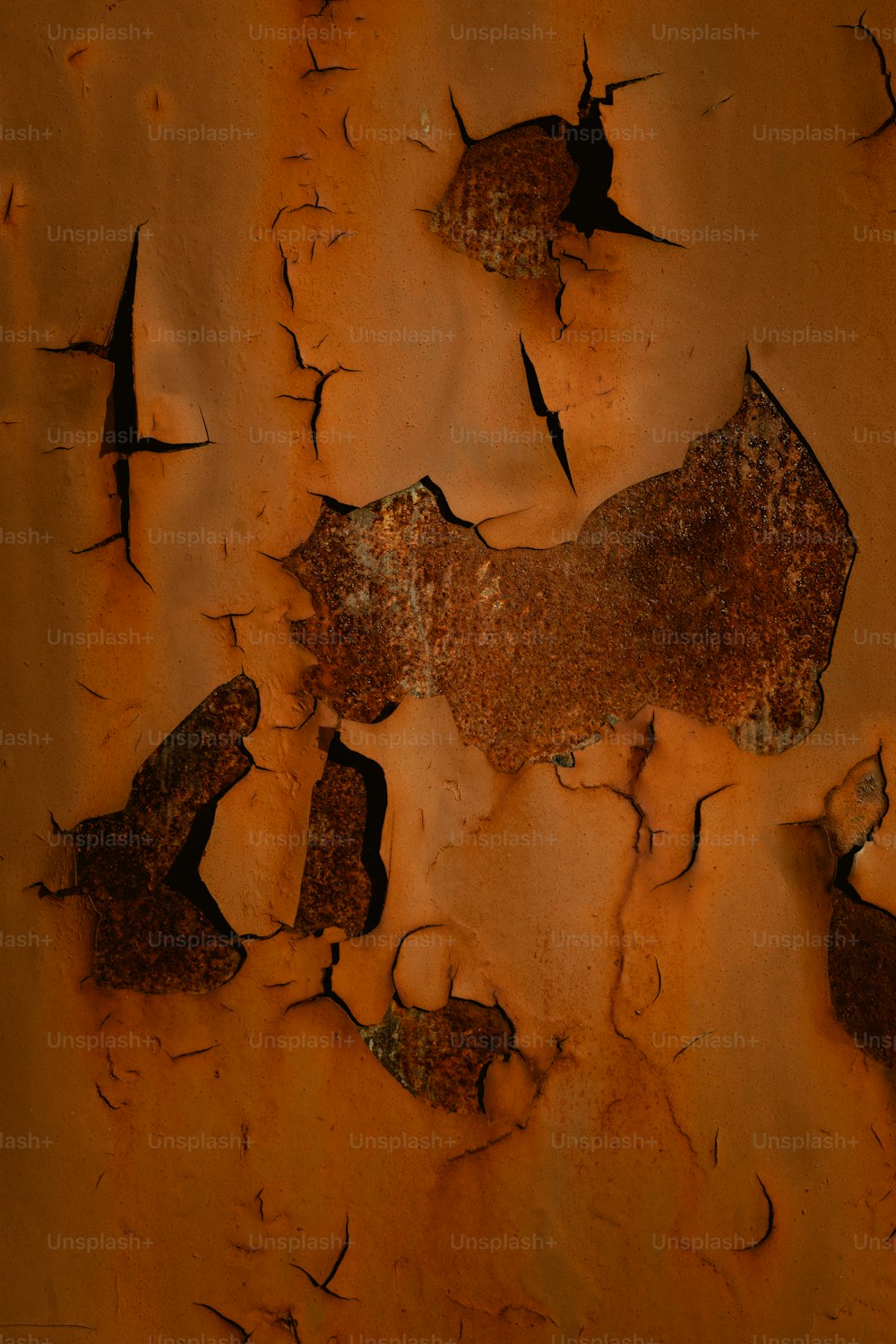 a rusted metal surface with cracks in it