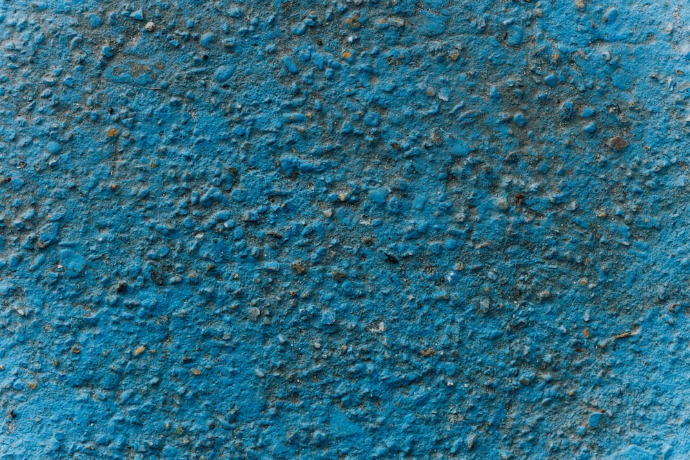 un gros plan d’un mur bleu avec de la saleté dessus