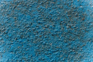 un primo piano di un muro blu con sporcizia su di esso