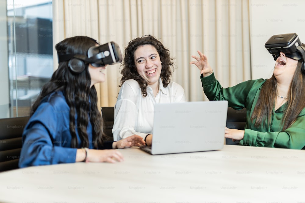 a group of women sitting around a table wearing virtual headsets