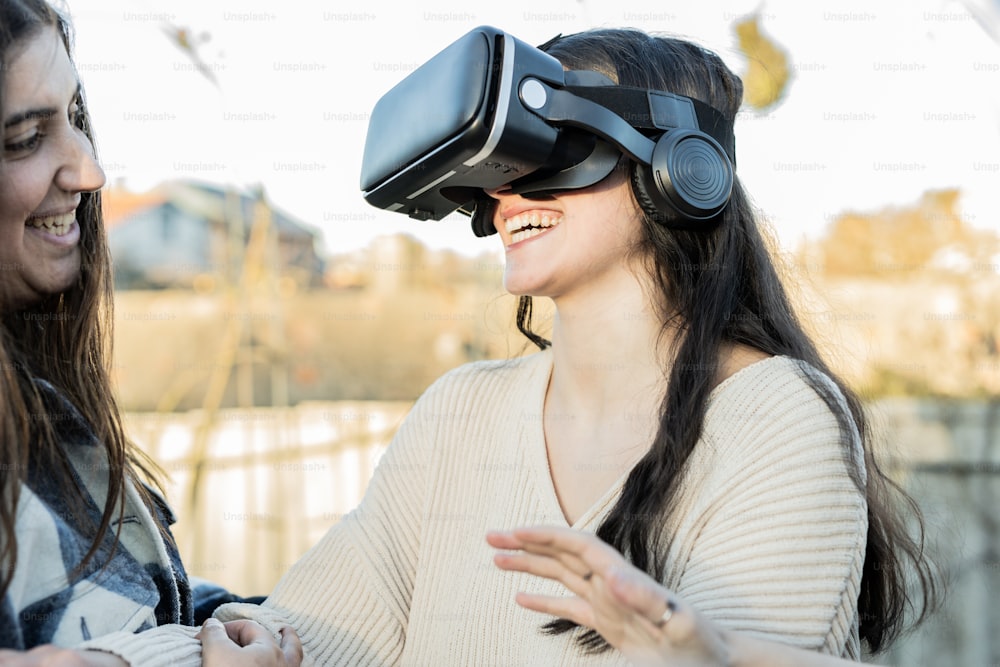 two women wearing virtual reality headsets and laughing