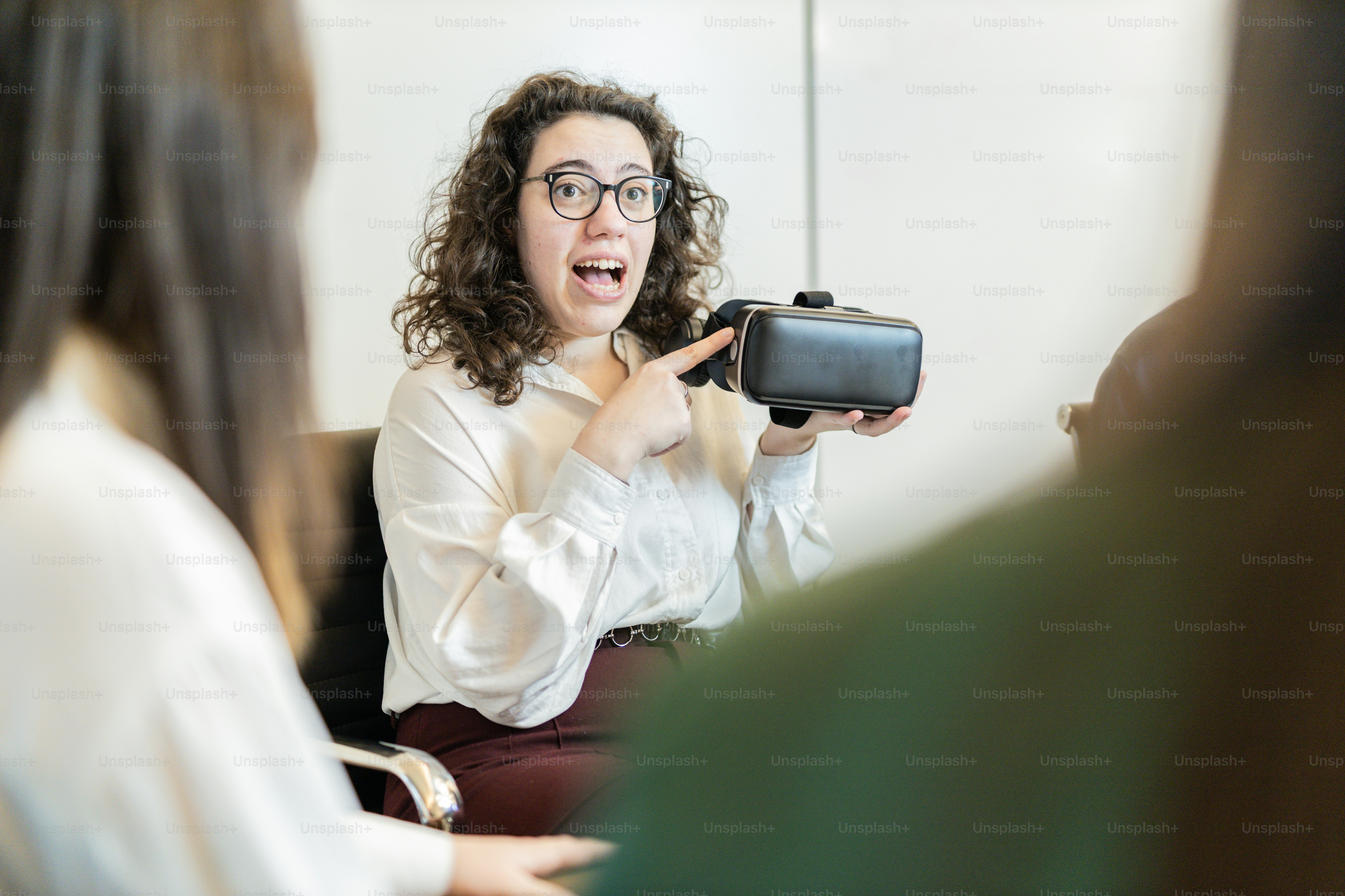 Eine Frau im weißen Hemd hält eine Kamera in der Hand
