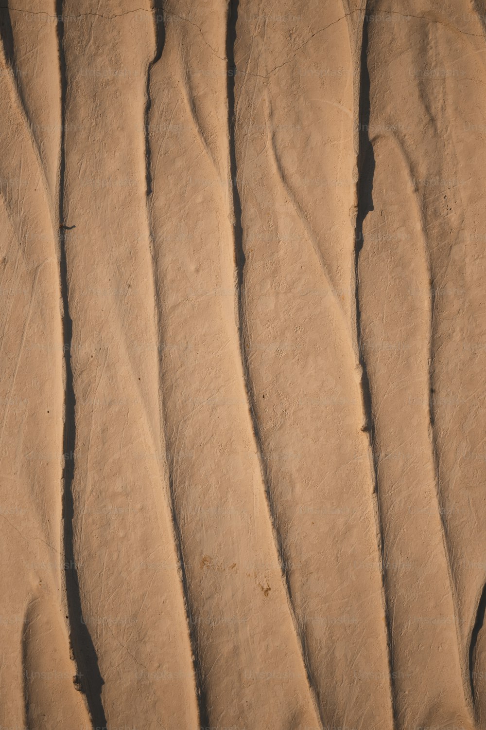 Un primo piano di una duna di sabbia con linee ondulate