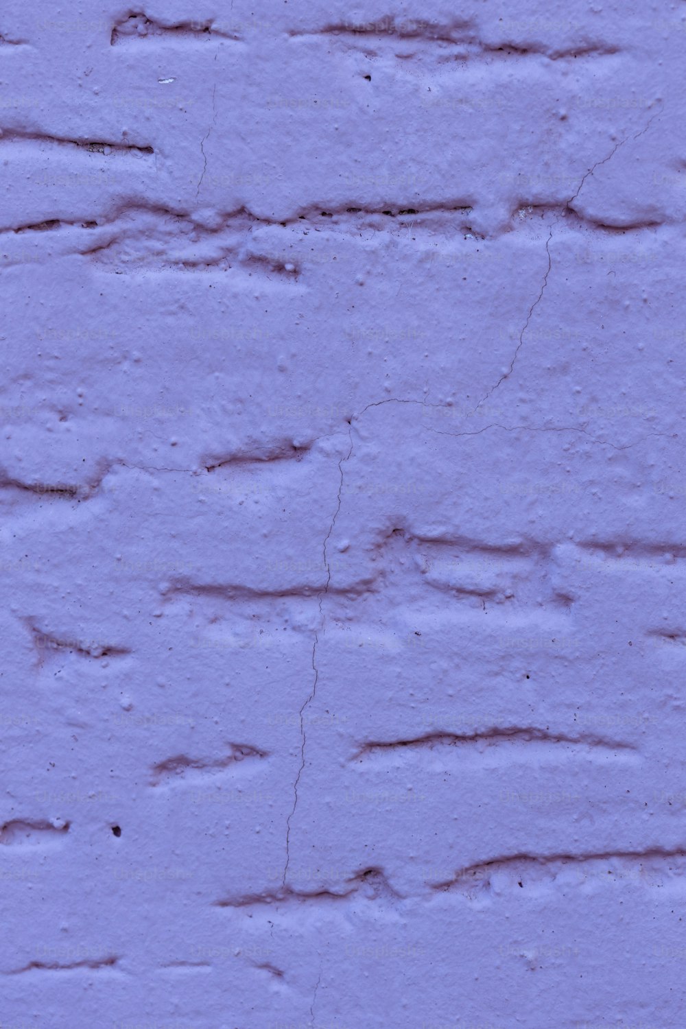 a blue brick wall with cracks in it