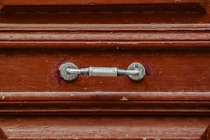 赤いドアの金属製のハンドルのクローズアップ