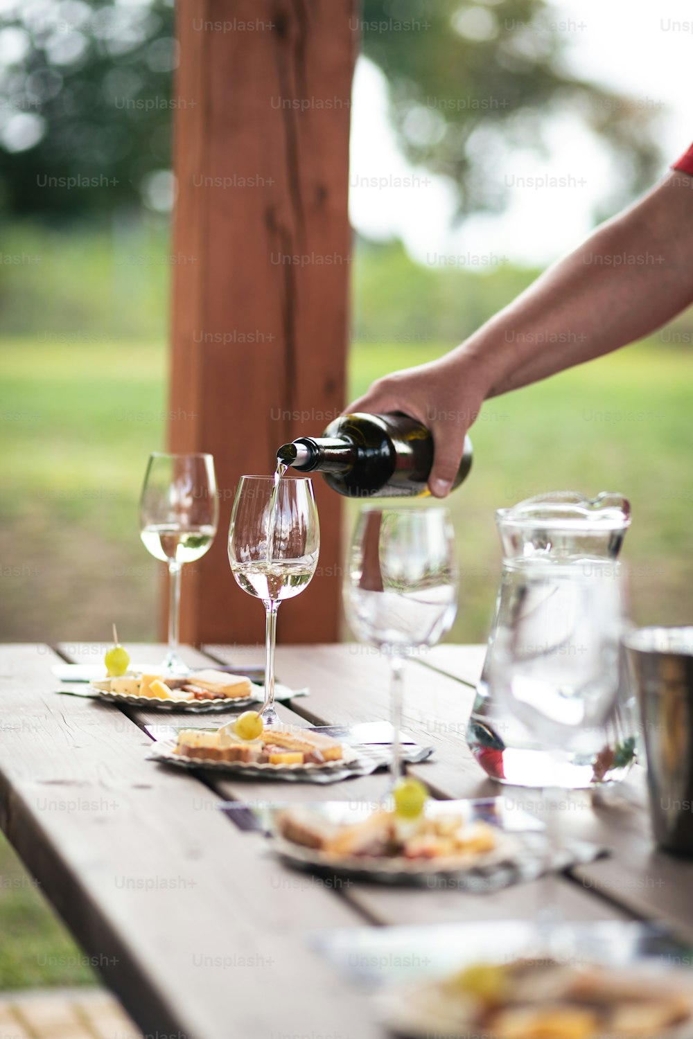 una persona che versa una bottiglia di vino su un piatto di cibo