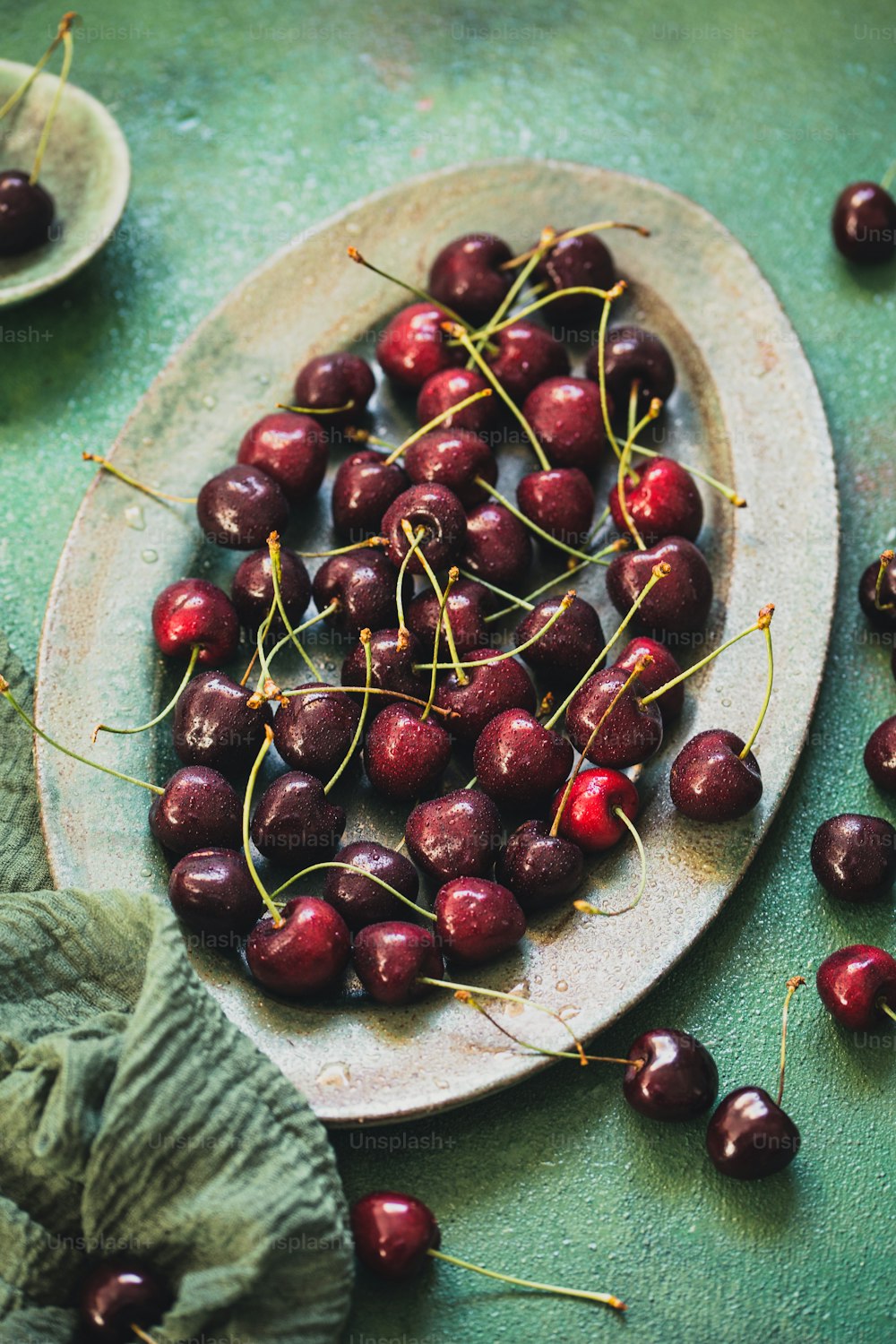 a plate full of cherries on a table